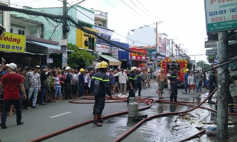 Một bình ga được đưa ra ngoài; rất đông người dân hiếu kỳ theo dõi. 